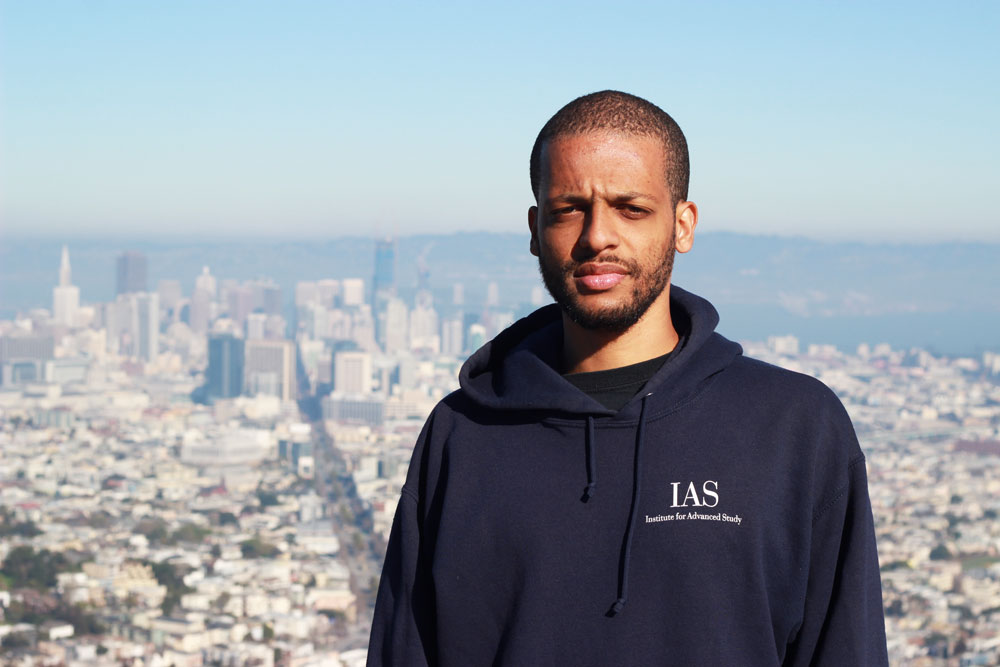 Jelani Nelson wearing a blue hoodie with San Fransisco in the background