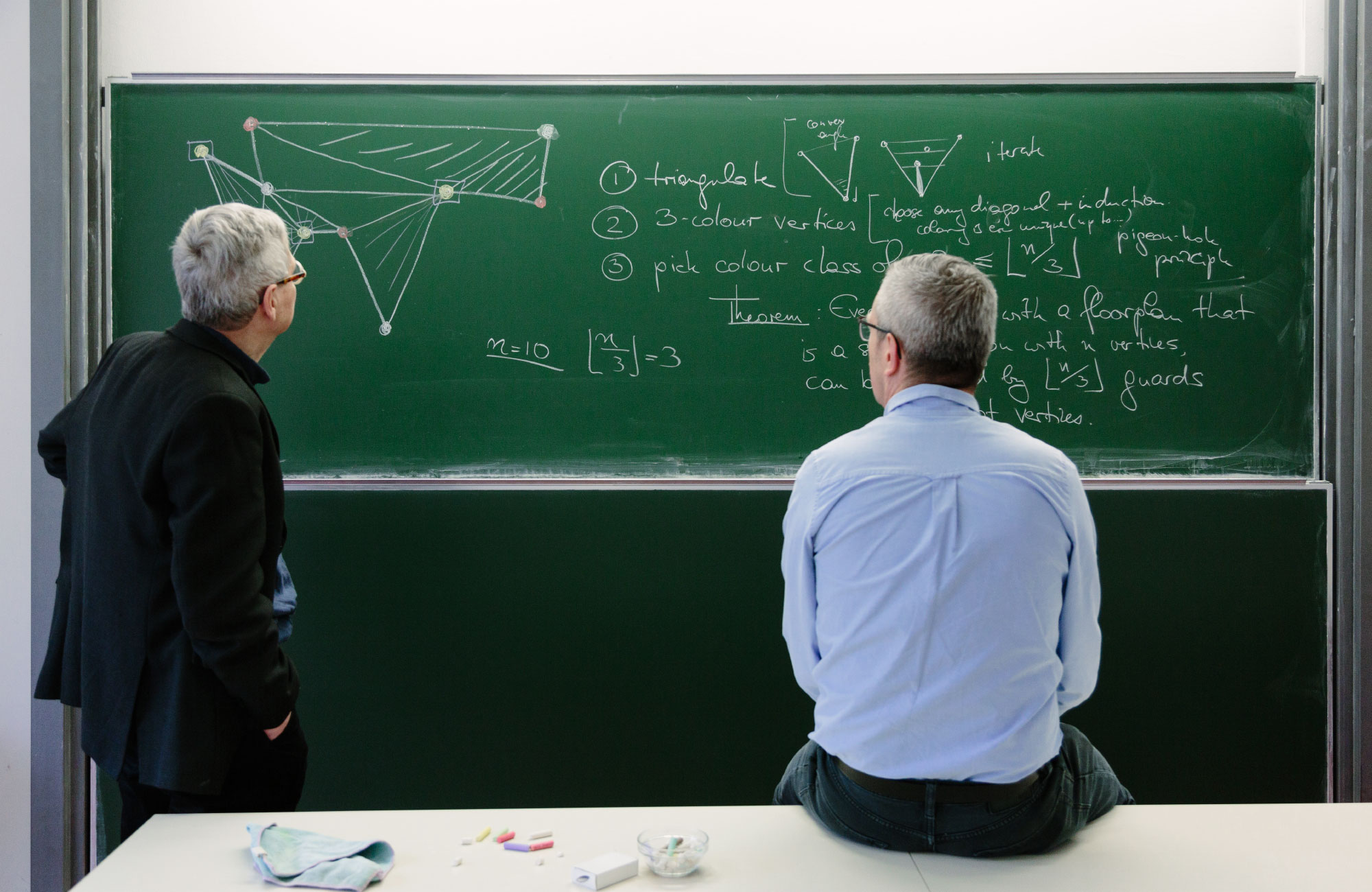 Mathematicians Prof. Günter M. Ziegler and Prof. Martin Aigner standing in front of a chalkboard