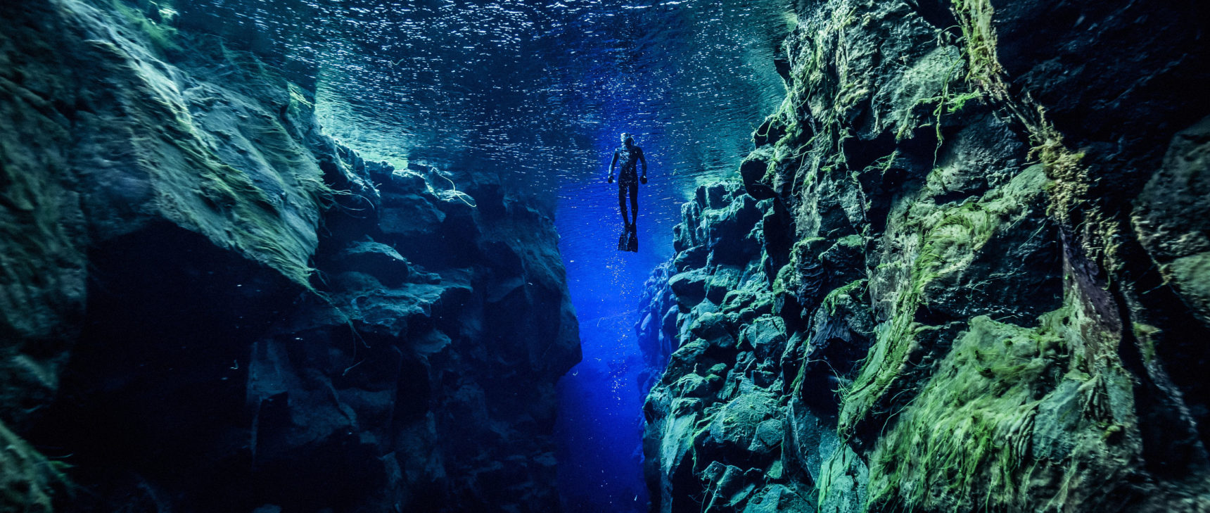 Photo of a diver between two tectonic plates in Silfra. reykjavik. Iceland