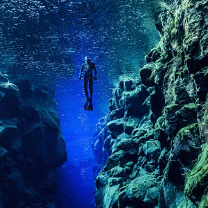 Photo of a diver between two tectonic plates in Silfra. reykjavik. Iceland