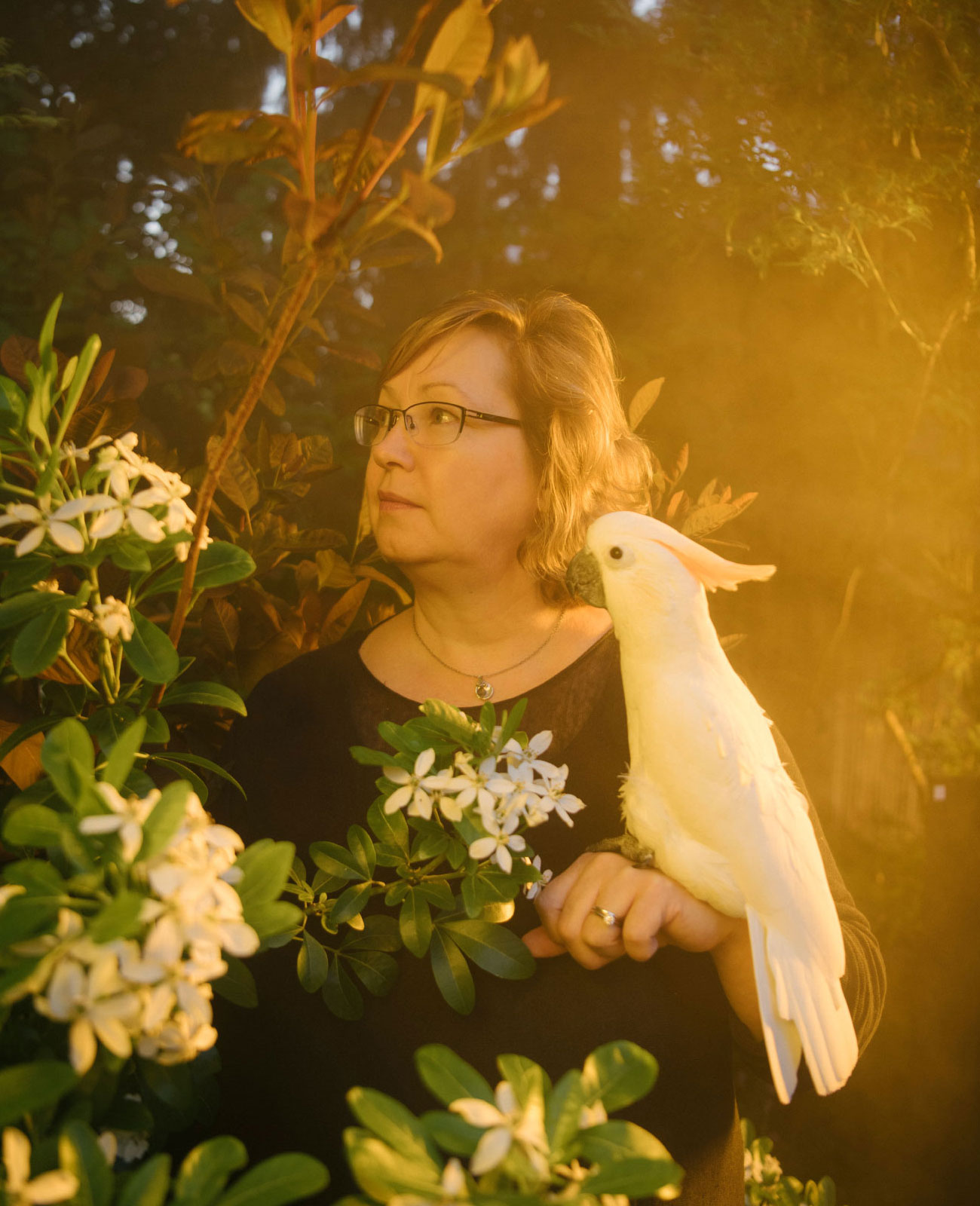 Victoria Meadows in her garden with her cockatoo.