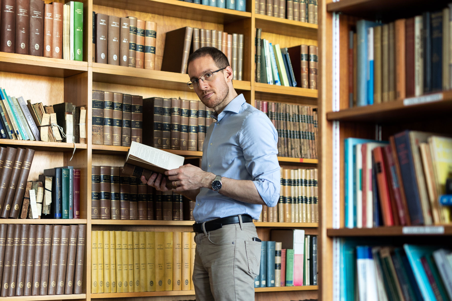 Photo of Alessio Figalli looking at Journals in the Library of Maths Department at Durham University