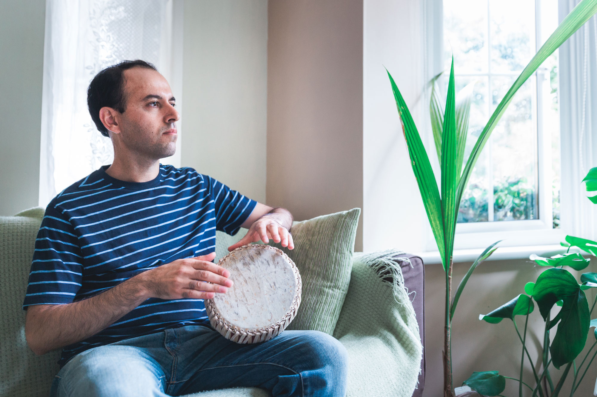 Caucher Birkar plays self-taught Kurdish beats on a small Thai drum in his family home near Cambridge, England