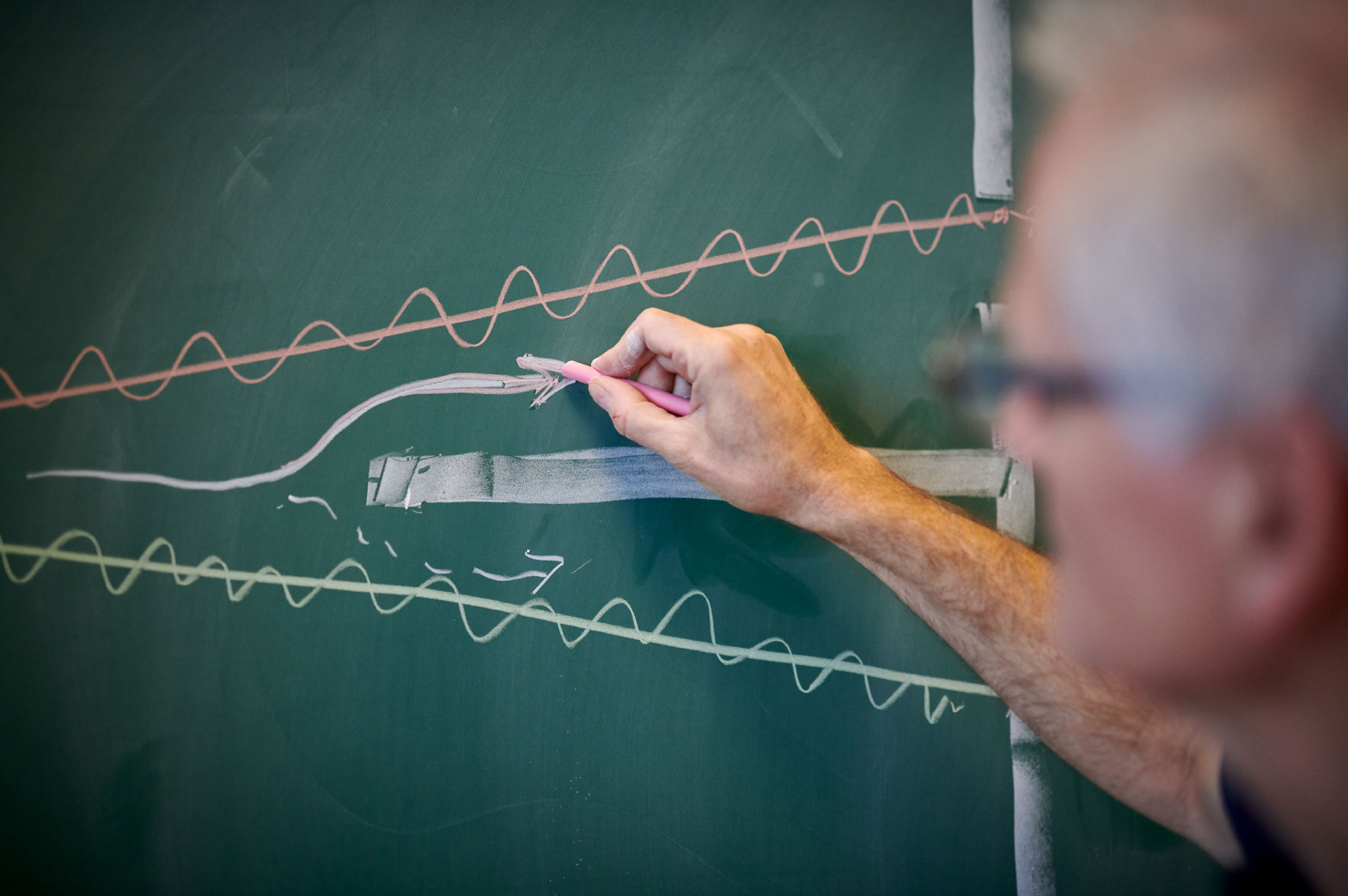 Photo of Tomas Bohr drawing on the chalkboard