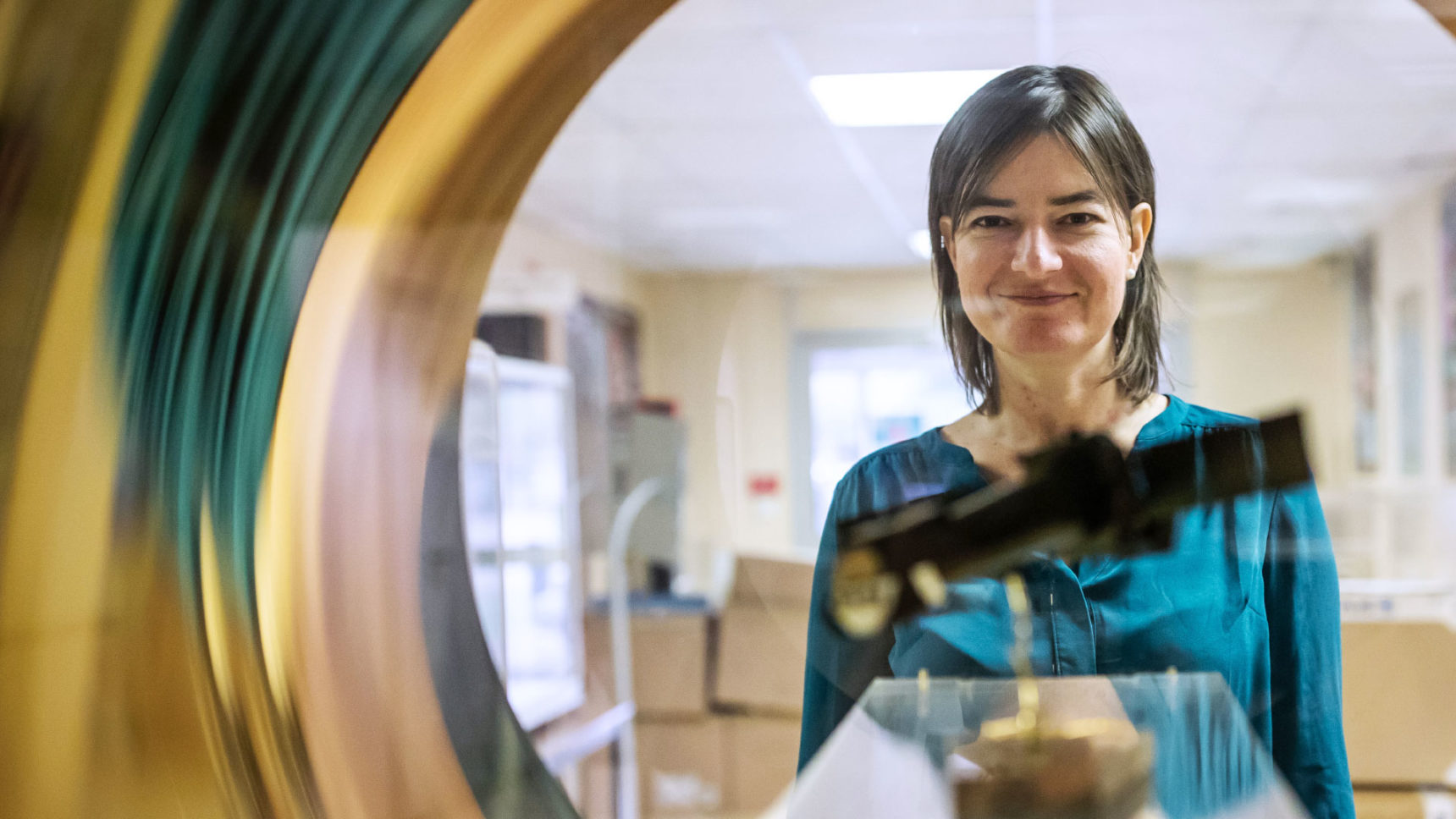 Valeria Pettorino looking through a model of a satellite.