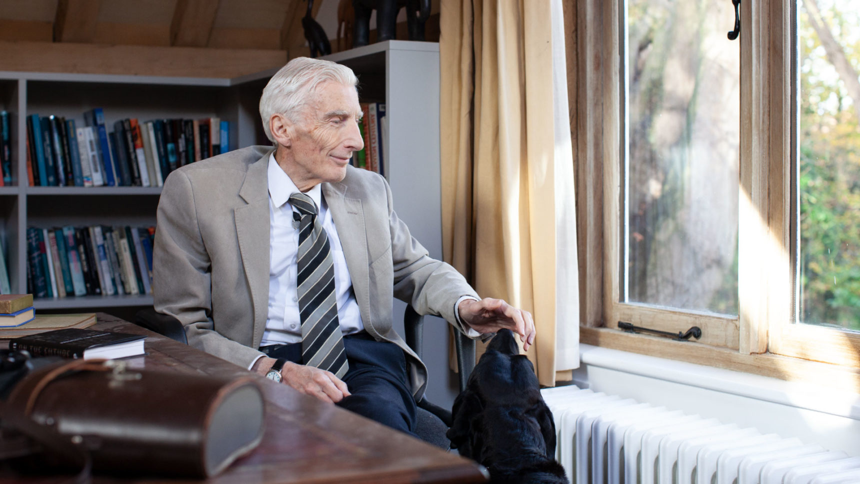 Martin Rees with his dog, Masha, in his home in Cambridge, England.