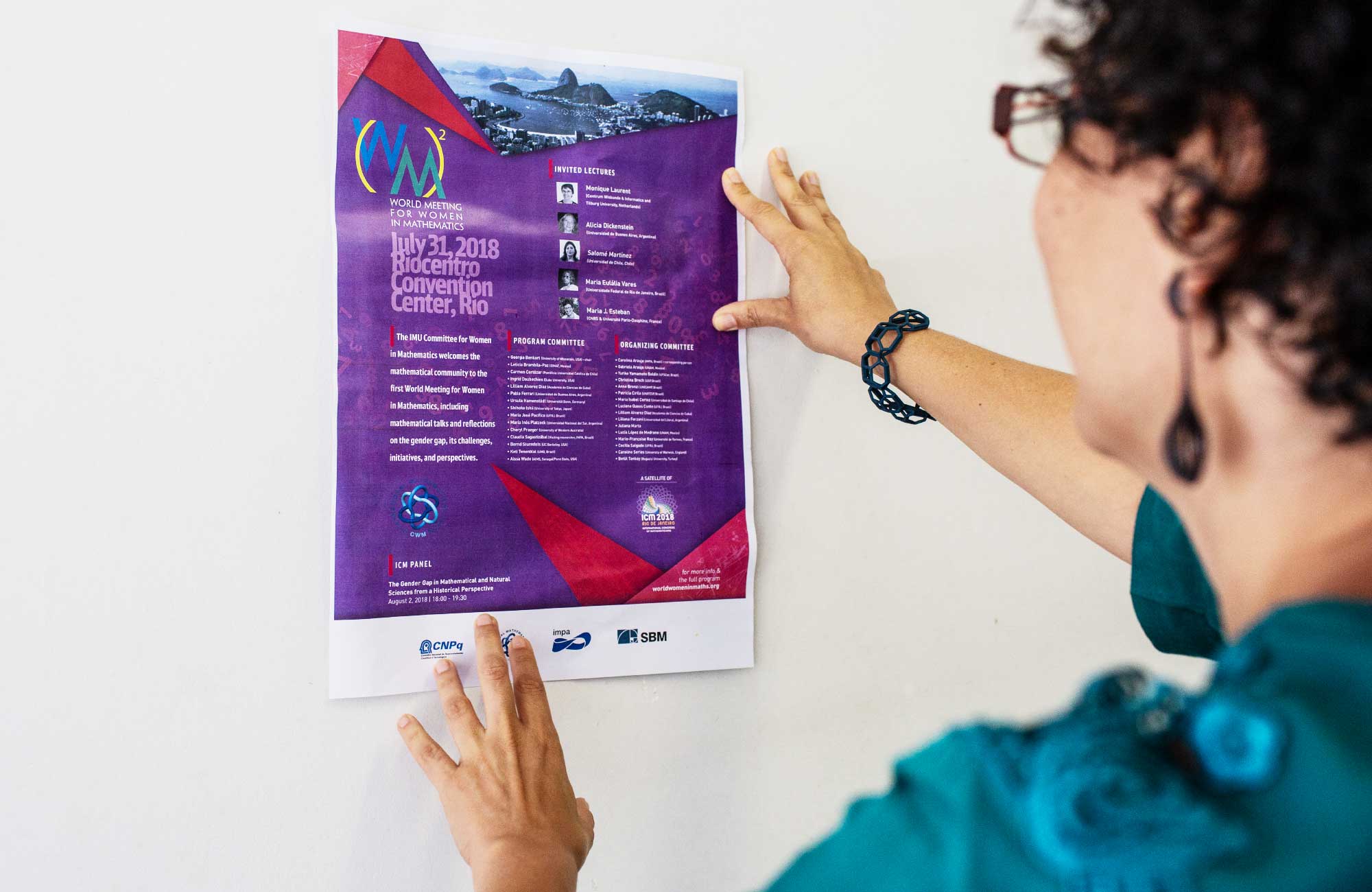 Carolina Araujo holding a poster for the World Meeting for Women in Mathematics