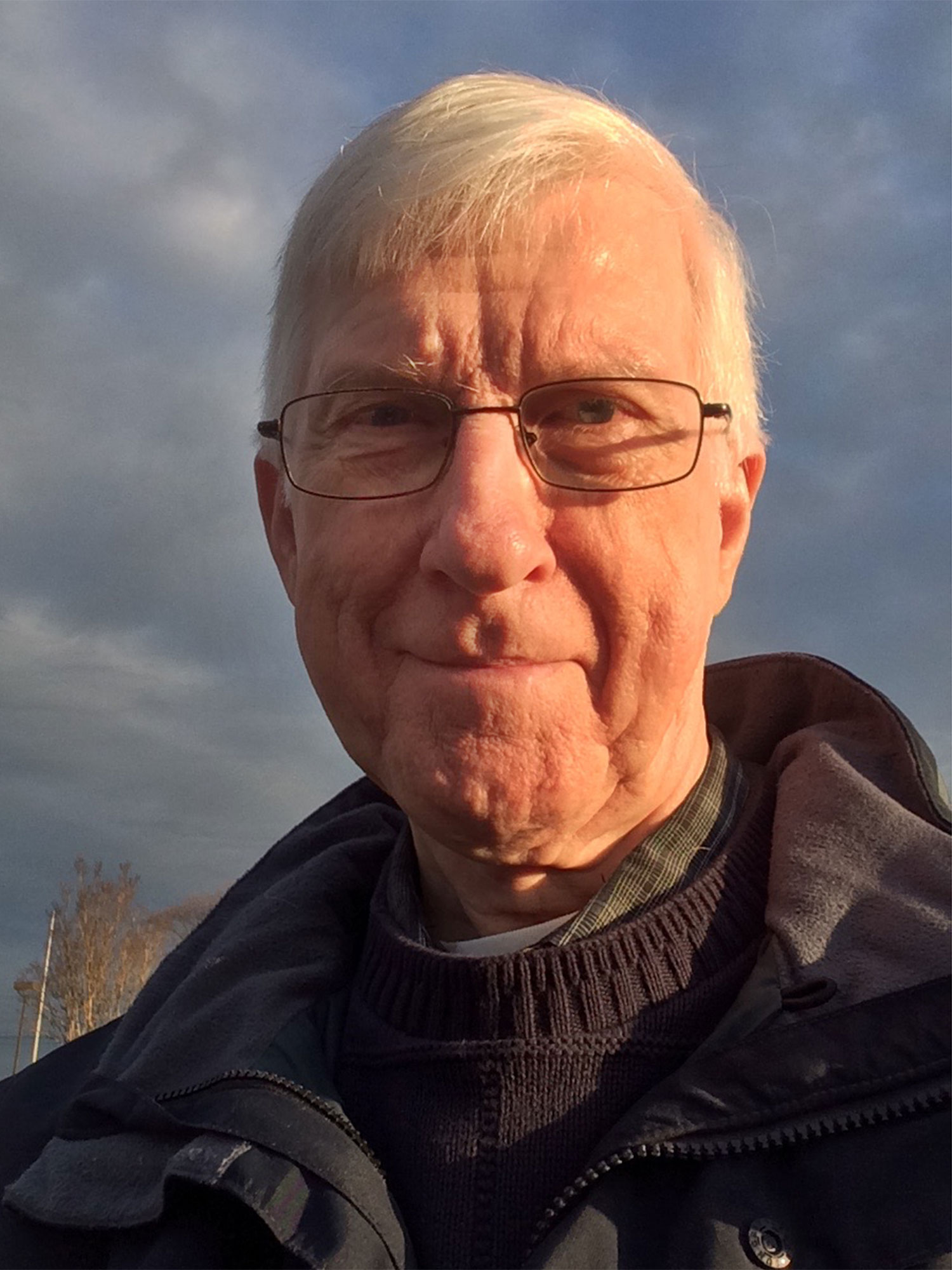 Photo of a caucasian man with thin black wireframe glasses looking into the camera.