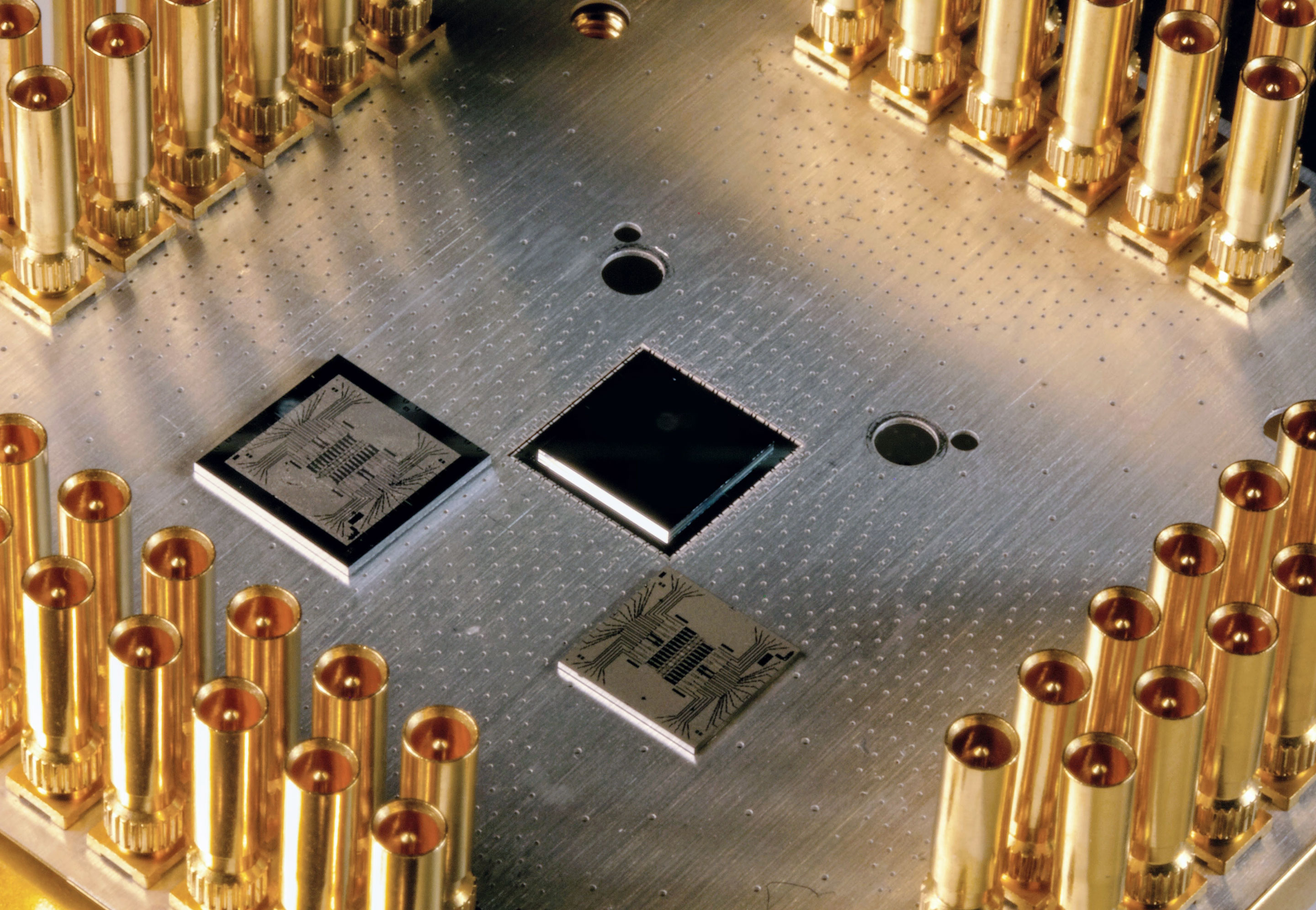 Photo of a silver metal plate with chips mounted on its surface.