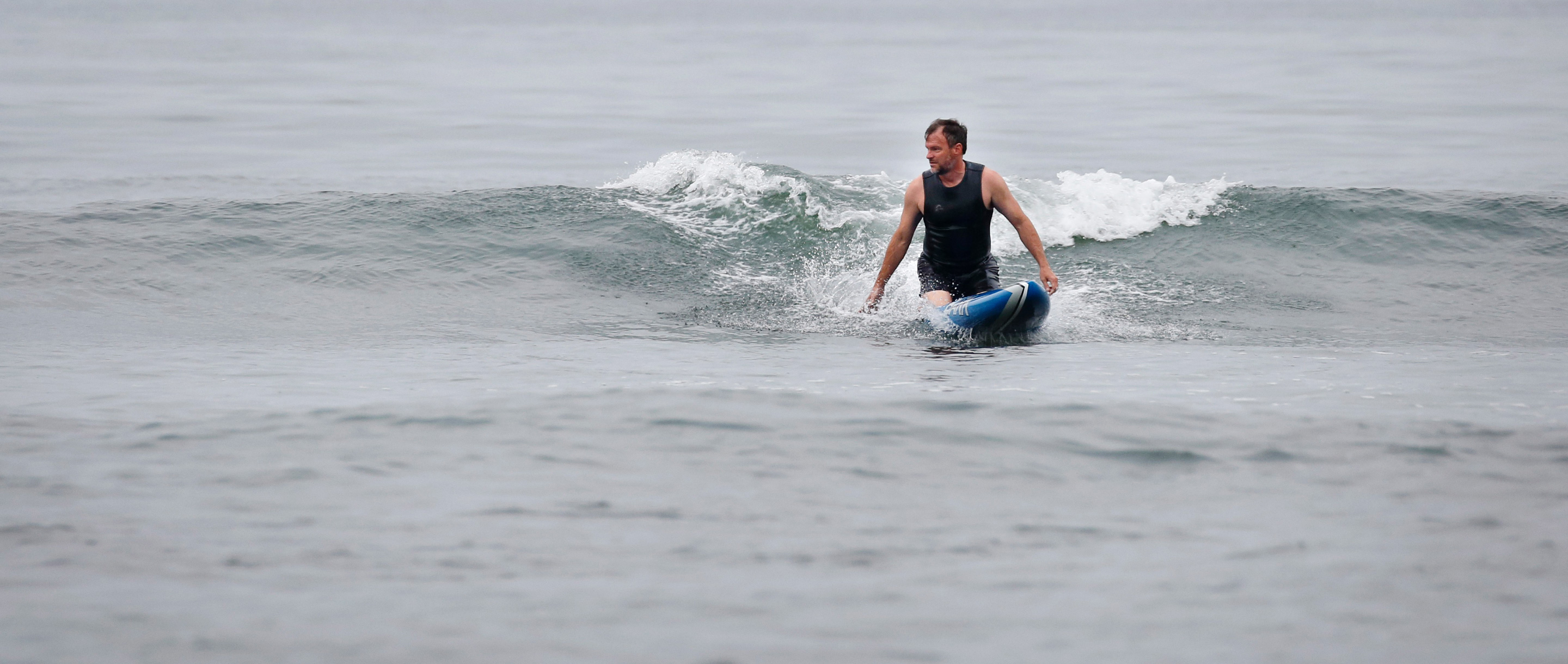 Craig Callender catches a wave on his paddleboard.