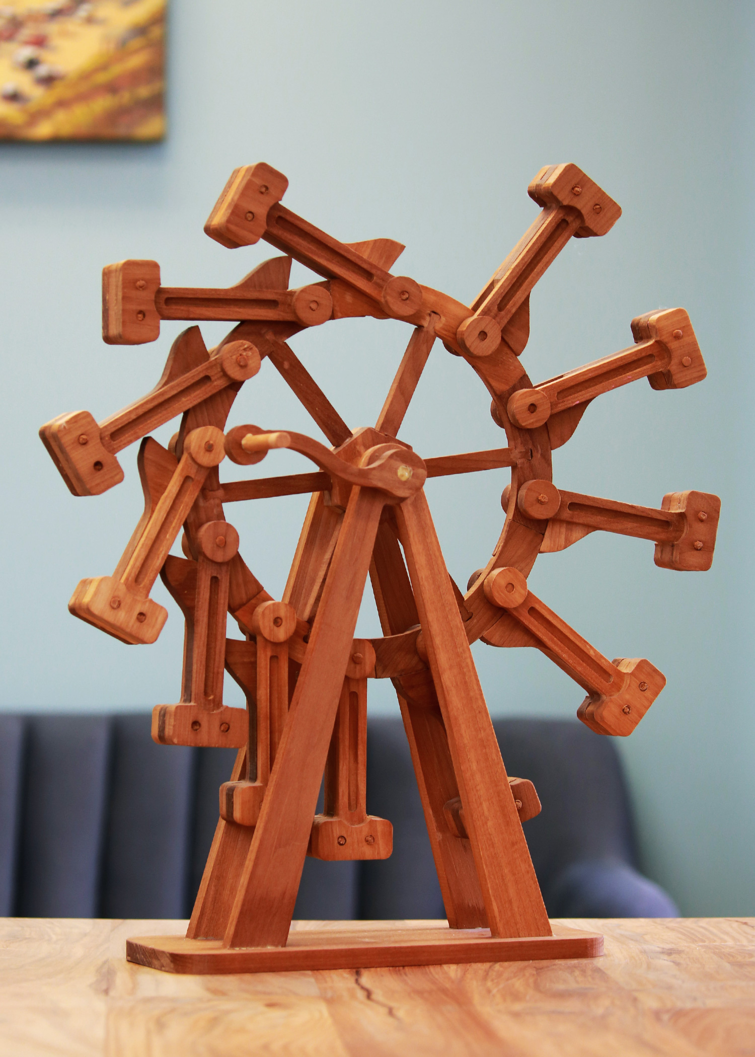 A wooden wheel with 12 wooden hammers hanging off the sides.