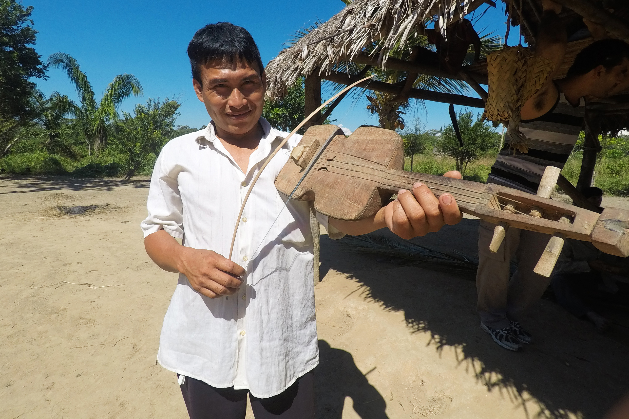 A Tsimané man plays an instrument resembling a violin.