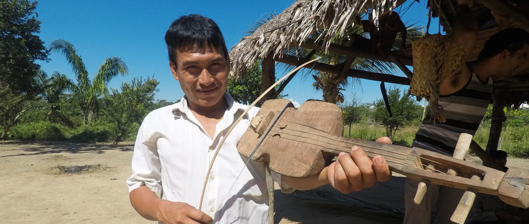 A Tsimané man plays an instrument resembling a violin.