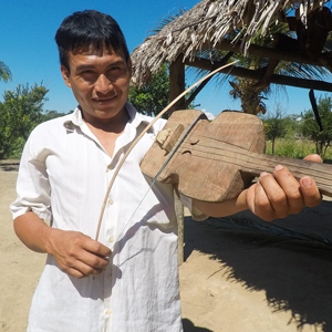 A Tsimané man plays an instrument resembling a violin.