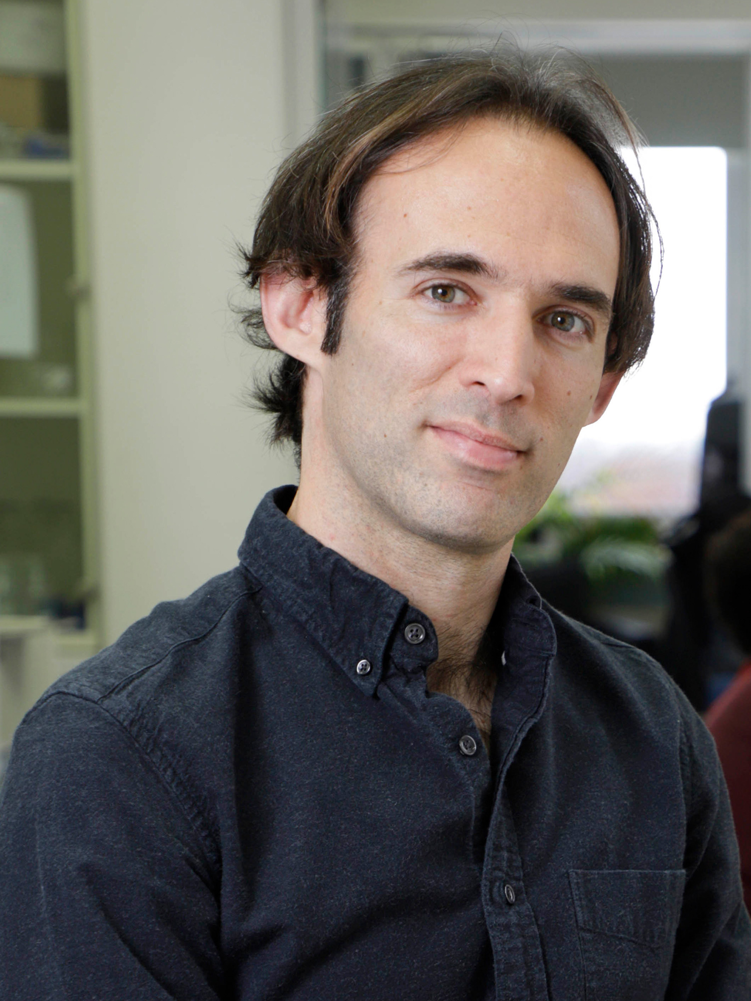 Photo of Oded Rechavi sitting in his laboratory at the University of Tel Aviv.