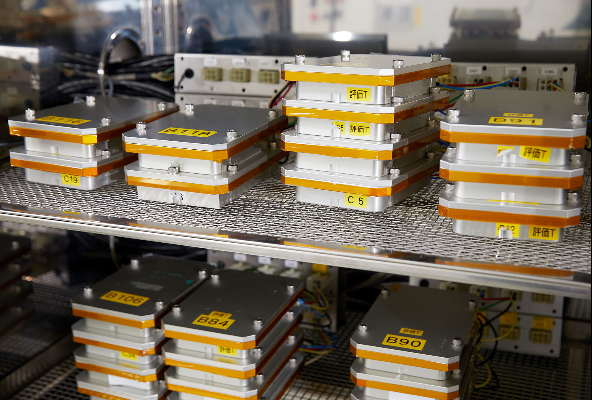 Stacks of unmounted lithium-ion batteries on metal shelves.