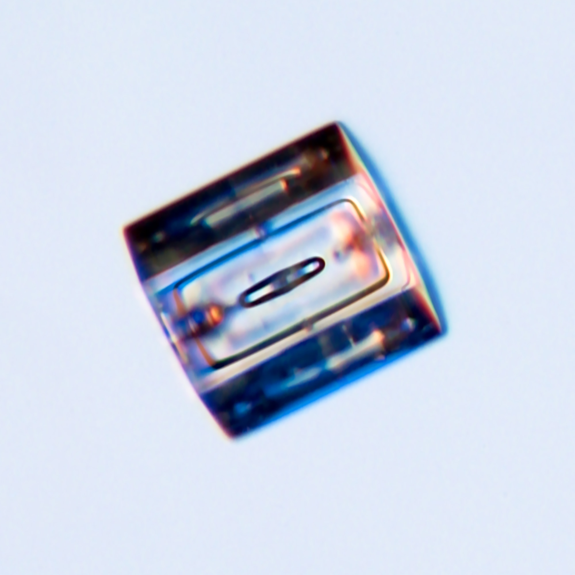 One of three close-up images of column-like snowflakes on a blue background.