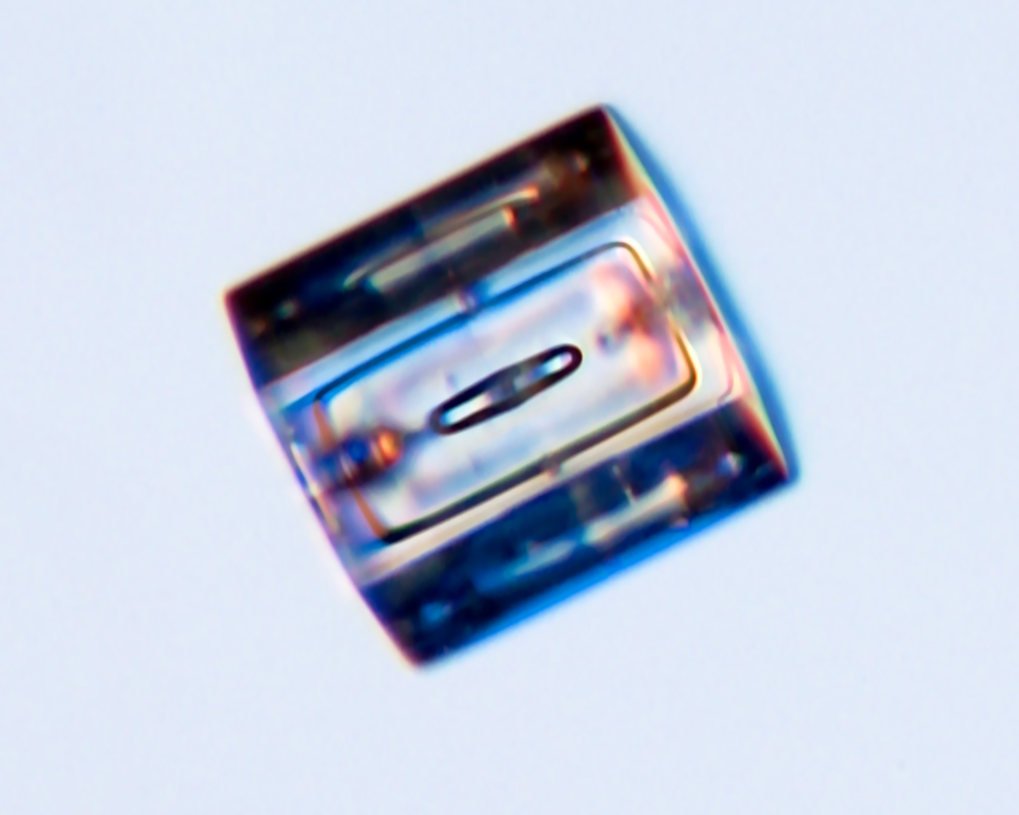 One of three close-up images of column-like snowflakes on a blue background.