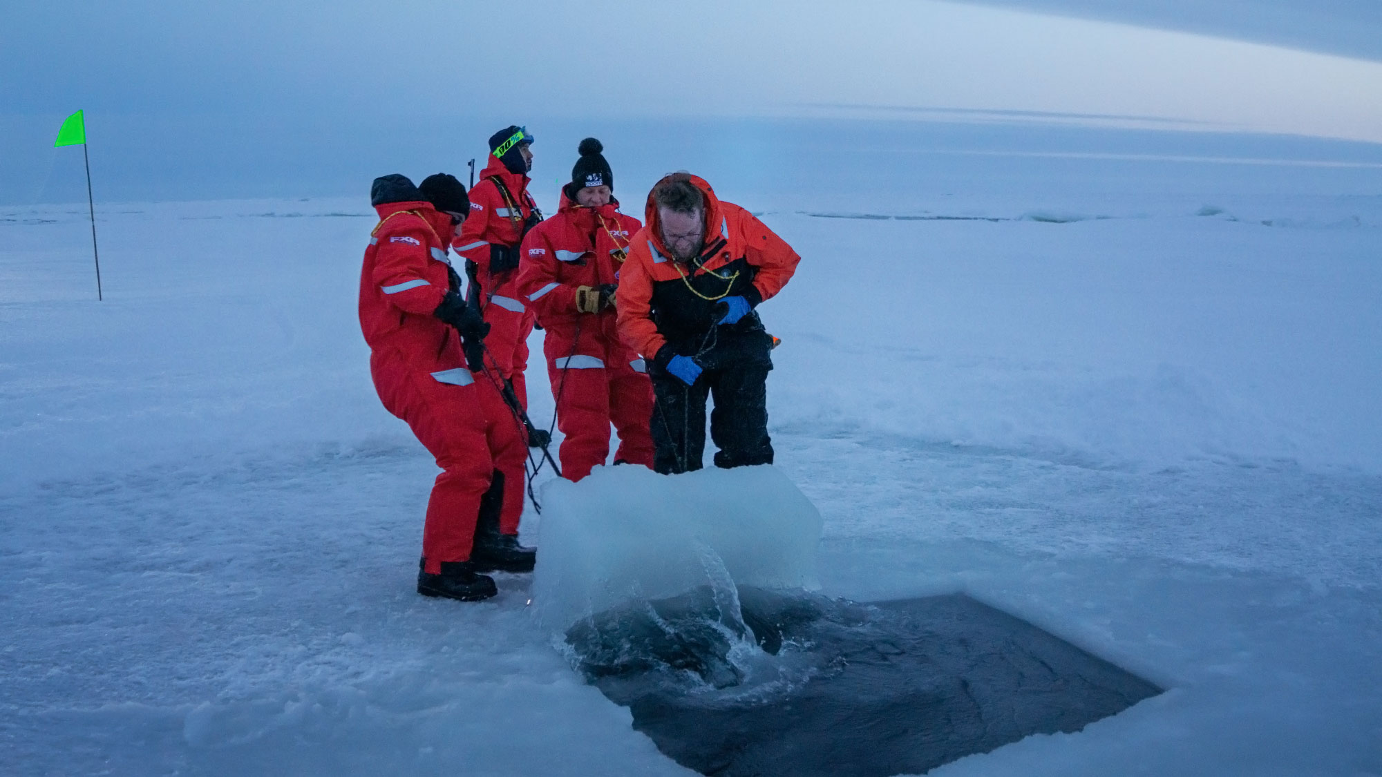 Scientists open a hole in arctic ice.