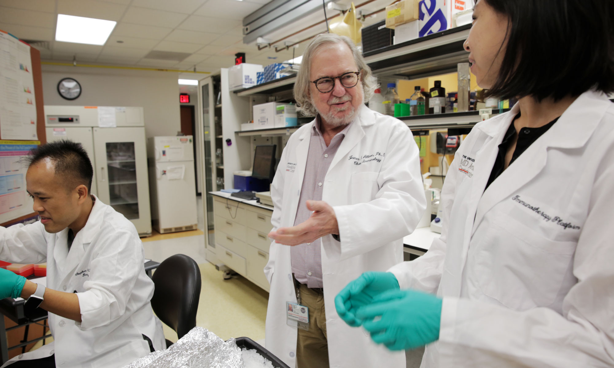 Allison speaks with members of his team in the laboratory.