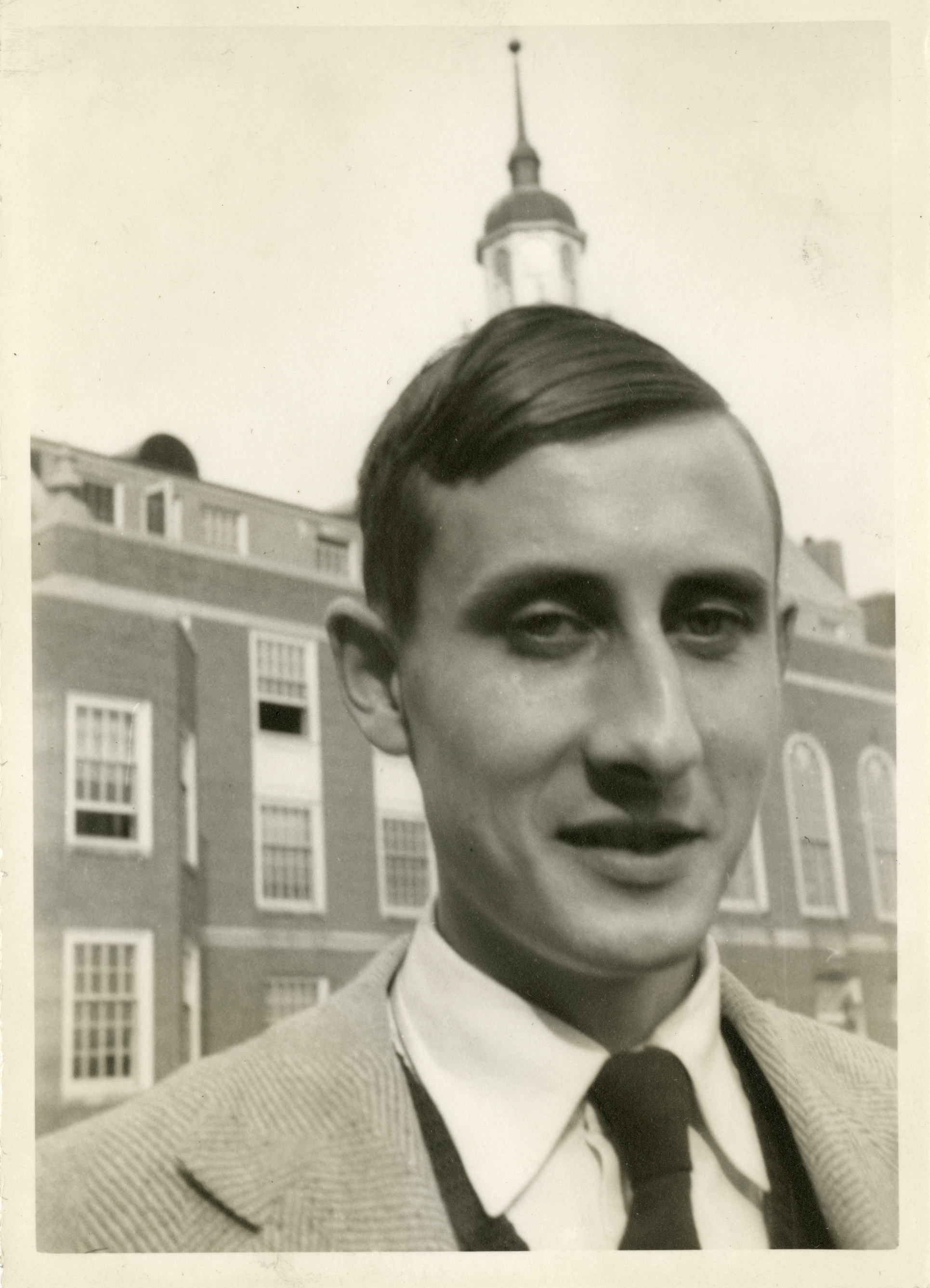 Black and white photo of Freeman Dyson as a young man in front of a building