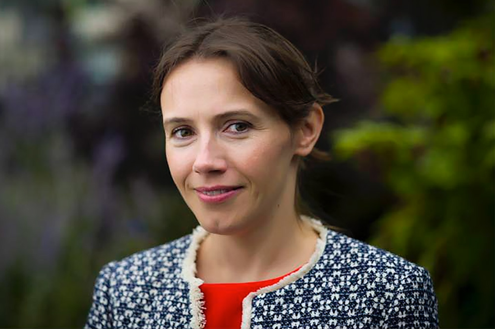 Portrait photo of Aiofe McLysaght, a geneticist at Trinity College Dublin, standing outside.