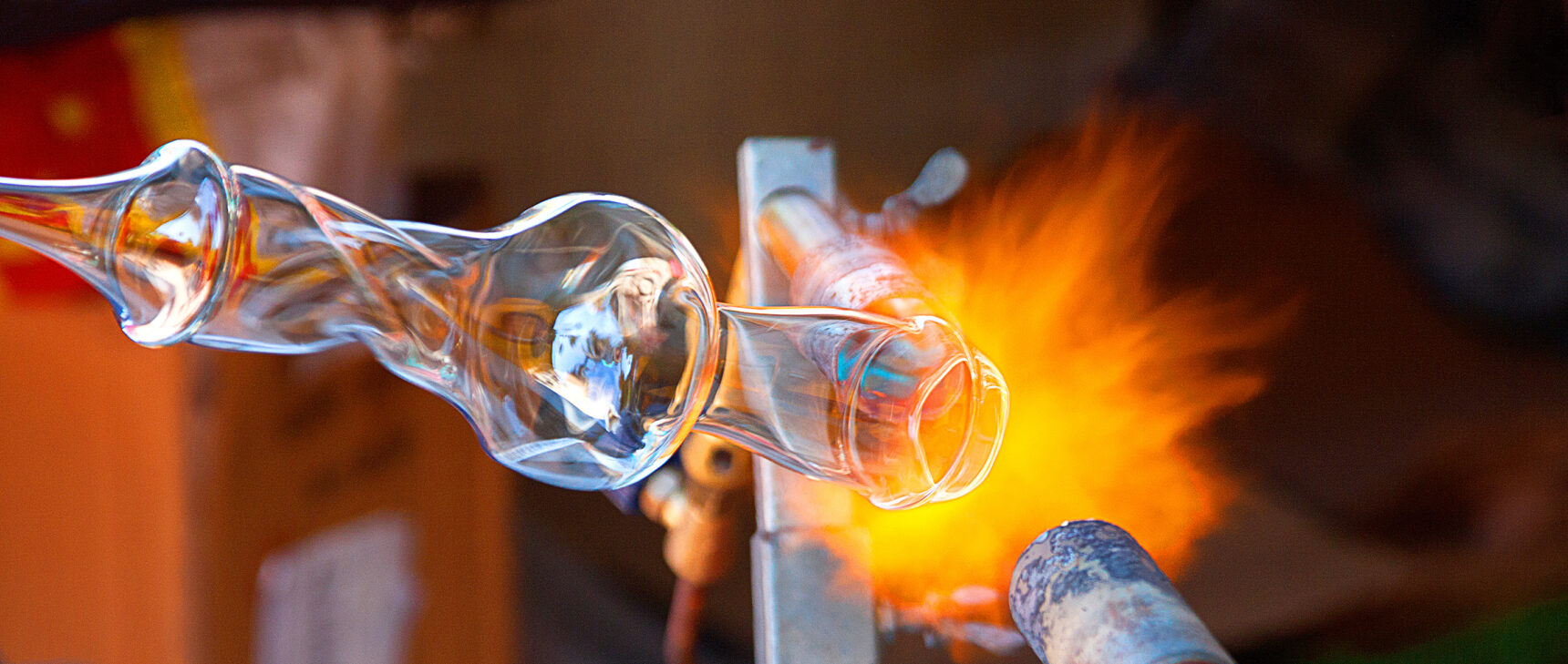 A glass object being shaped by a blowtorch.]