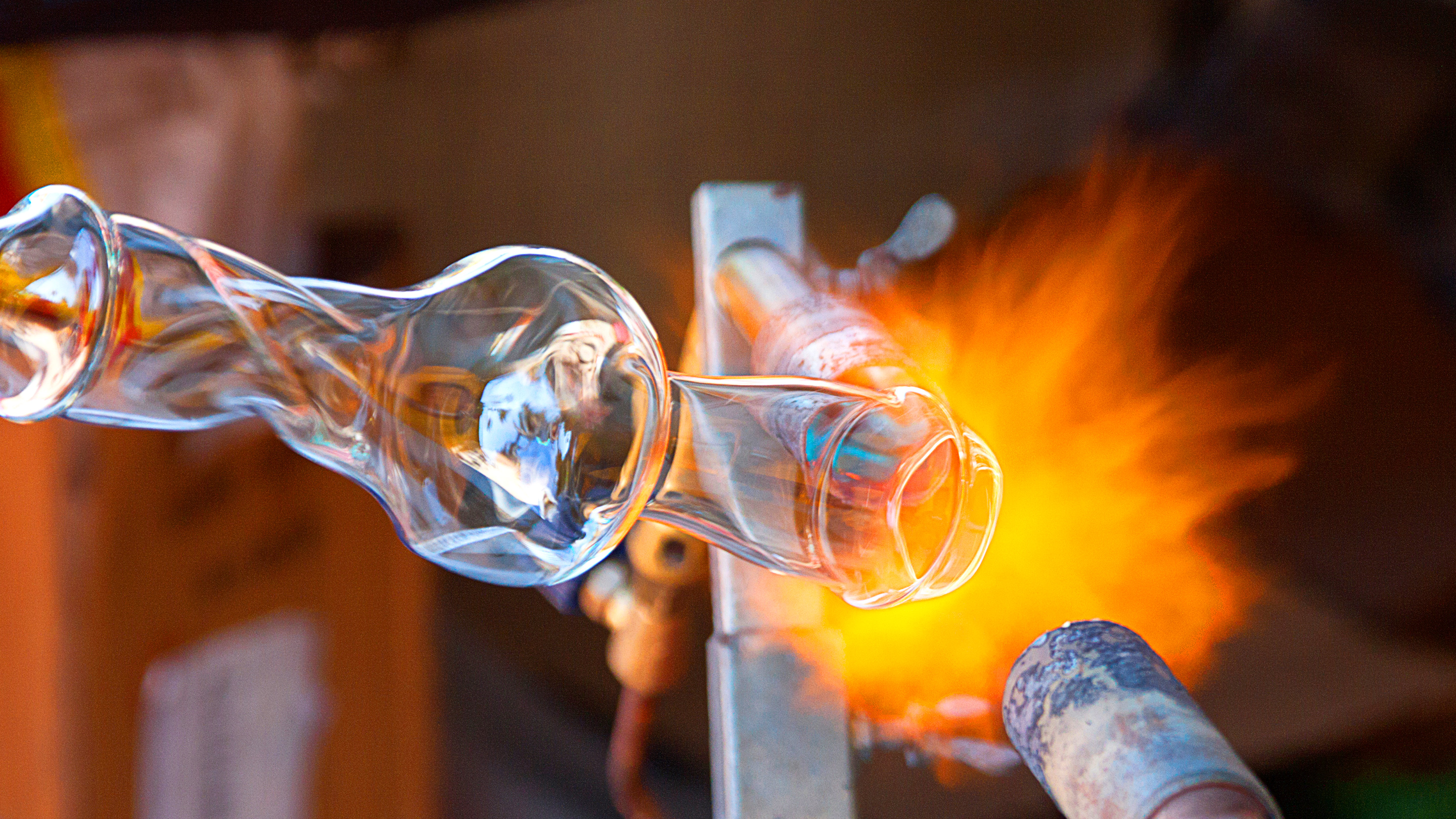 A glass object being shaped by a blowtorch.]