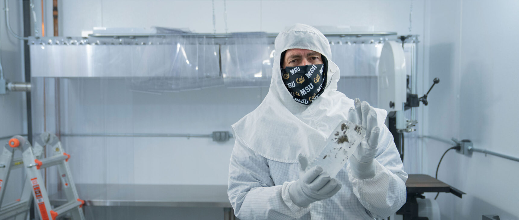 John Priscu holds an ice core sample in a sterile laboratory.