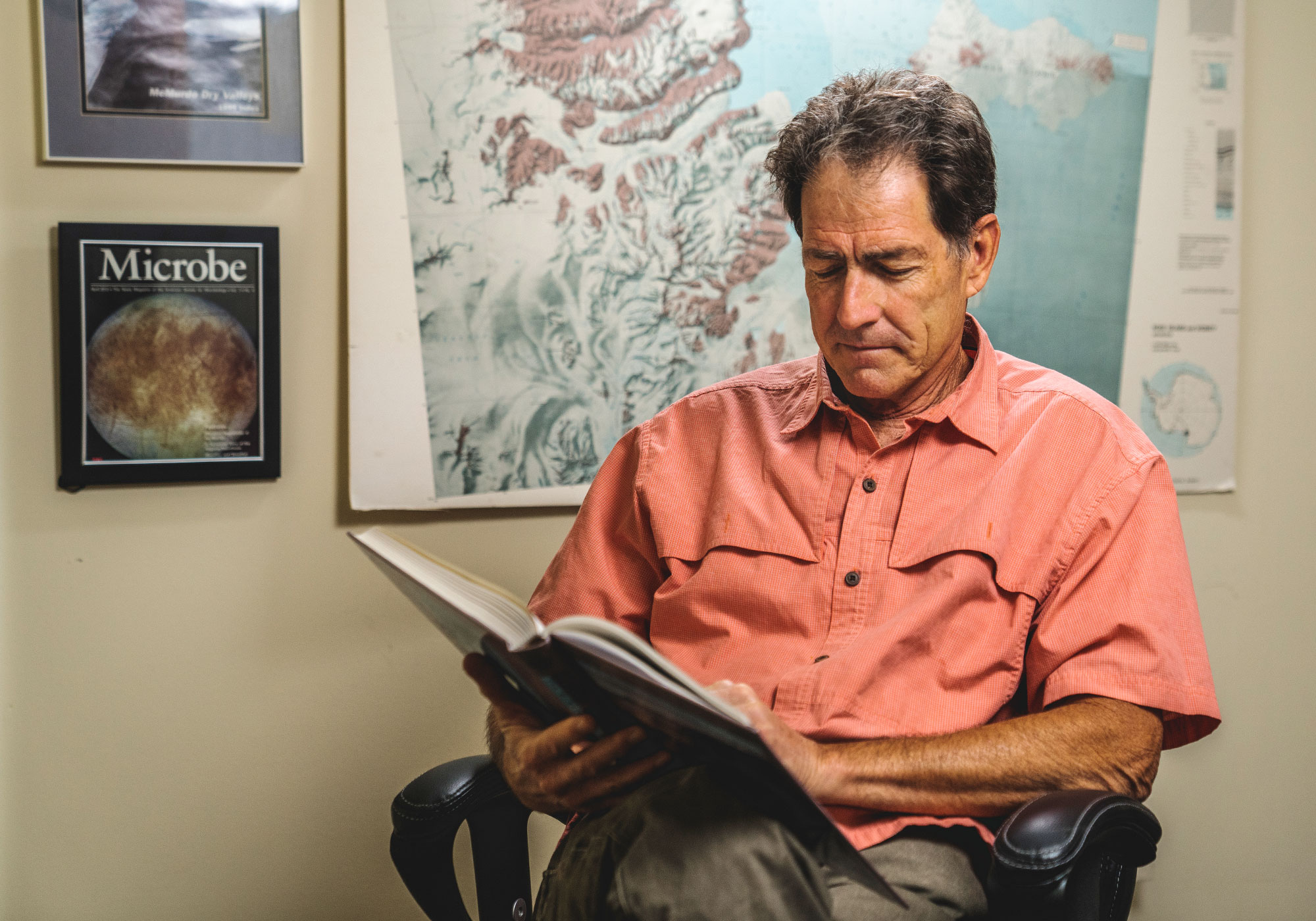 Priscu reads in a chair in his office.