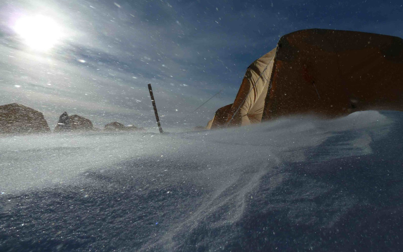 Wind blowing snow past a tent in Antarctica.