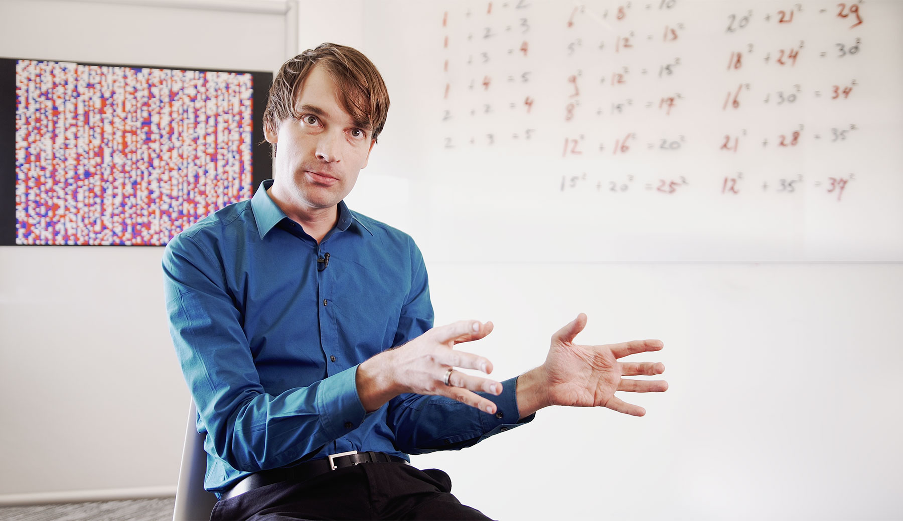 Photo of Marijn Heule in a blue shirt sitting in a white room