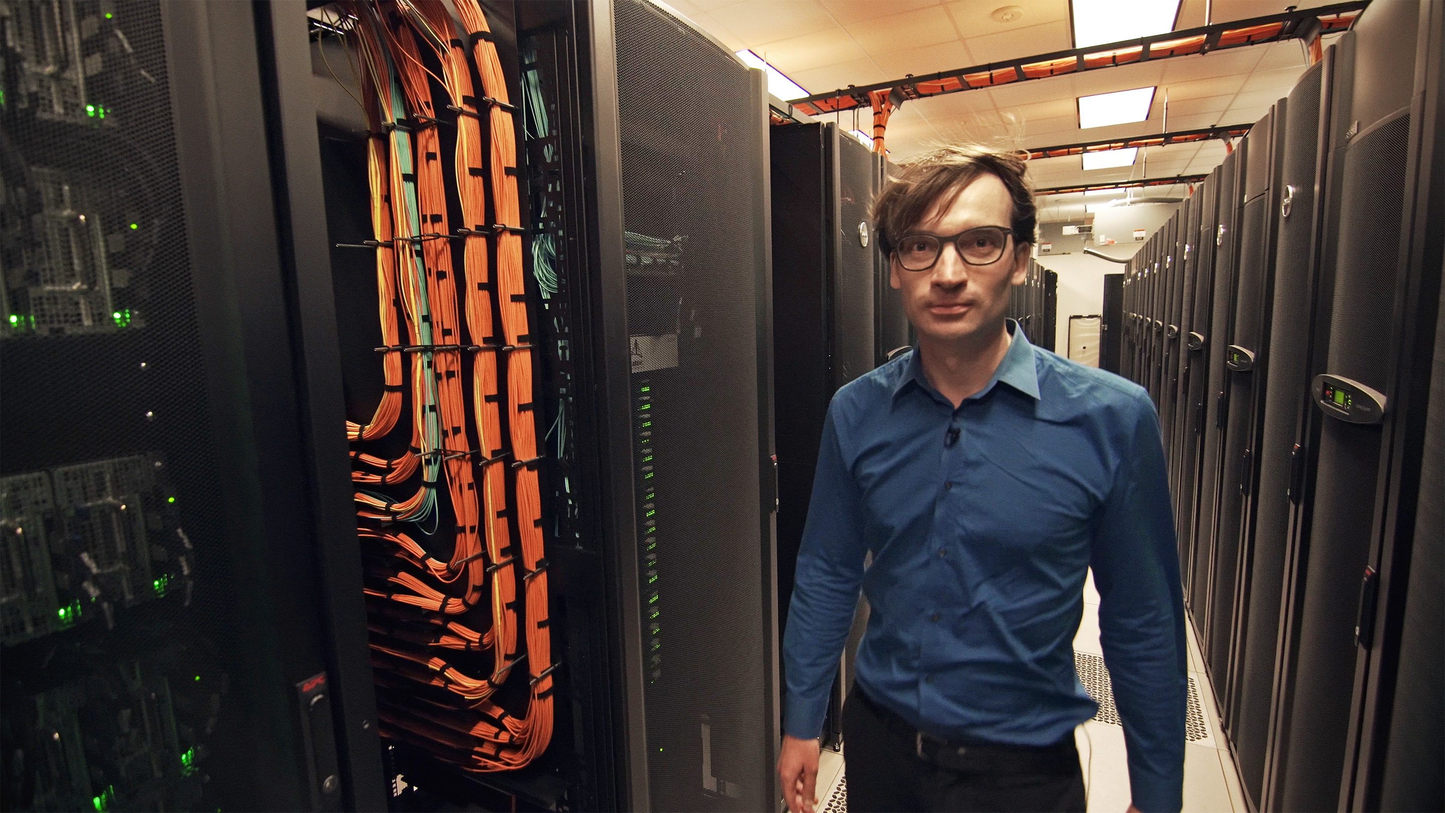 Photo of Marijn Heule walking among computer processors