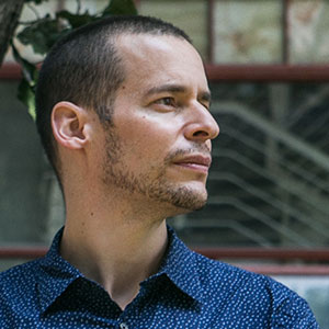 Computer scientist and complexity researcher Carlos Gershenson of the National Autonomous University of Mexico stands by a busy urban roadway.