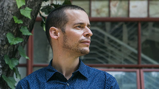 Computer scientist and complexity researcher Carlos Gershenson of the National Autonomous University of Mexico stands by a busy urban roadway.