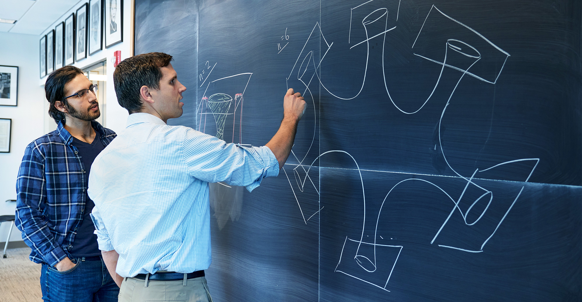 Tom Hartman and Amirhossein Tajdi at a chalkboard.