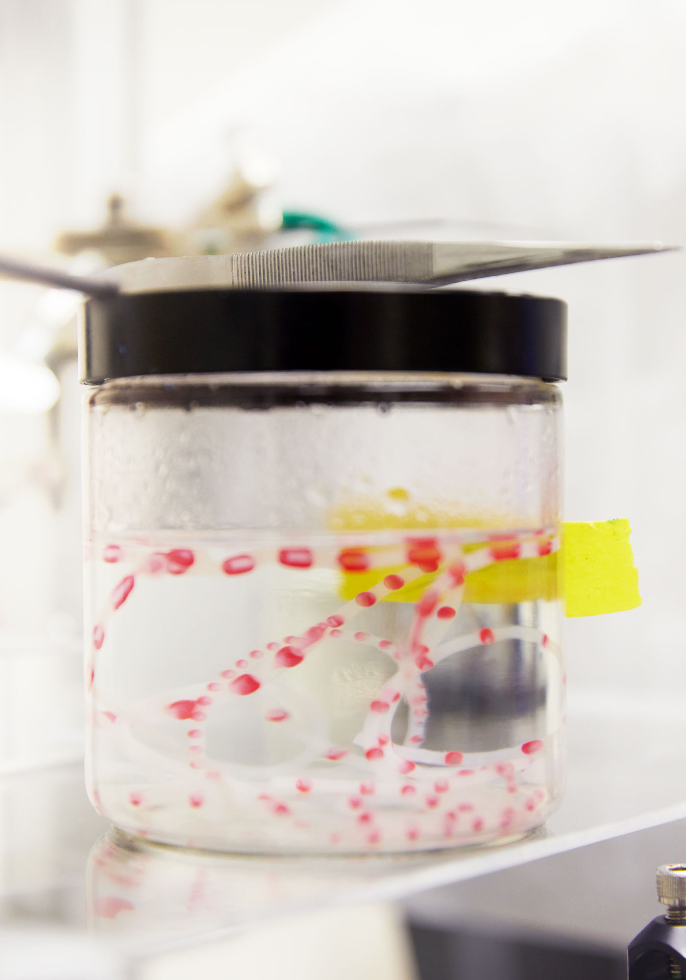 A jar containing drops of a red liquid suspended in a clear liquid