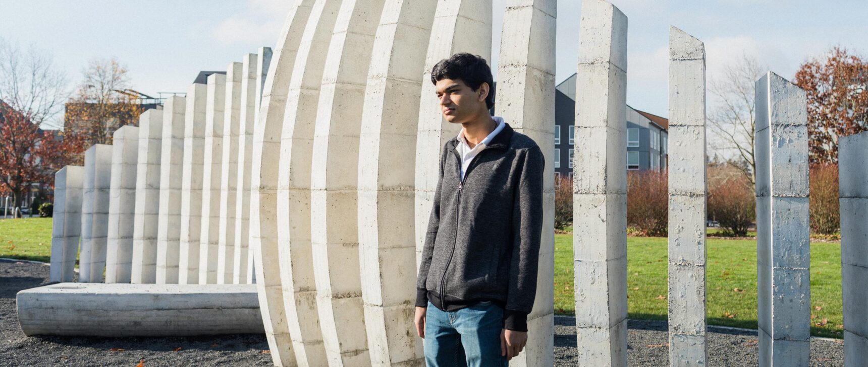 Photo of Ashwin Sah standing in front of a sculpture in a park