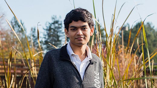 Photo of Ashwin Sah standing in front of a sculpture in a park