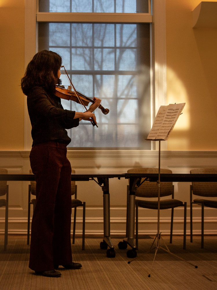 A diptych. On left, Lauren Williams standing and playing the violin in front of sheet music. On the right, Williams playing the violin as a child.