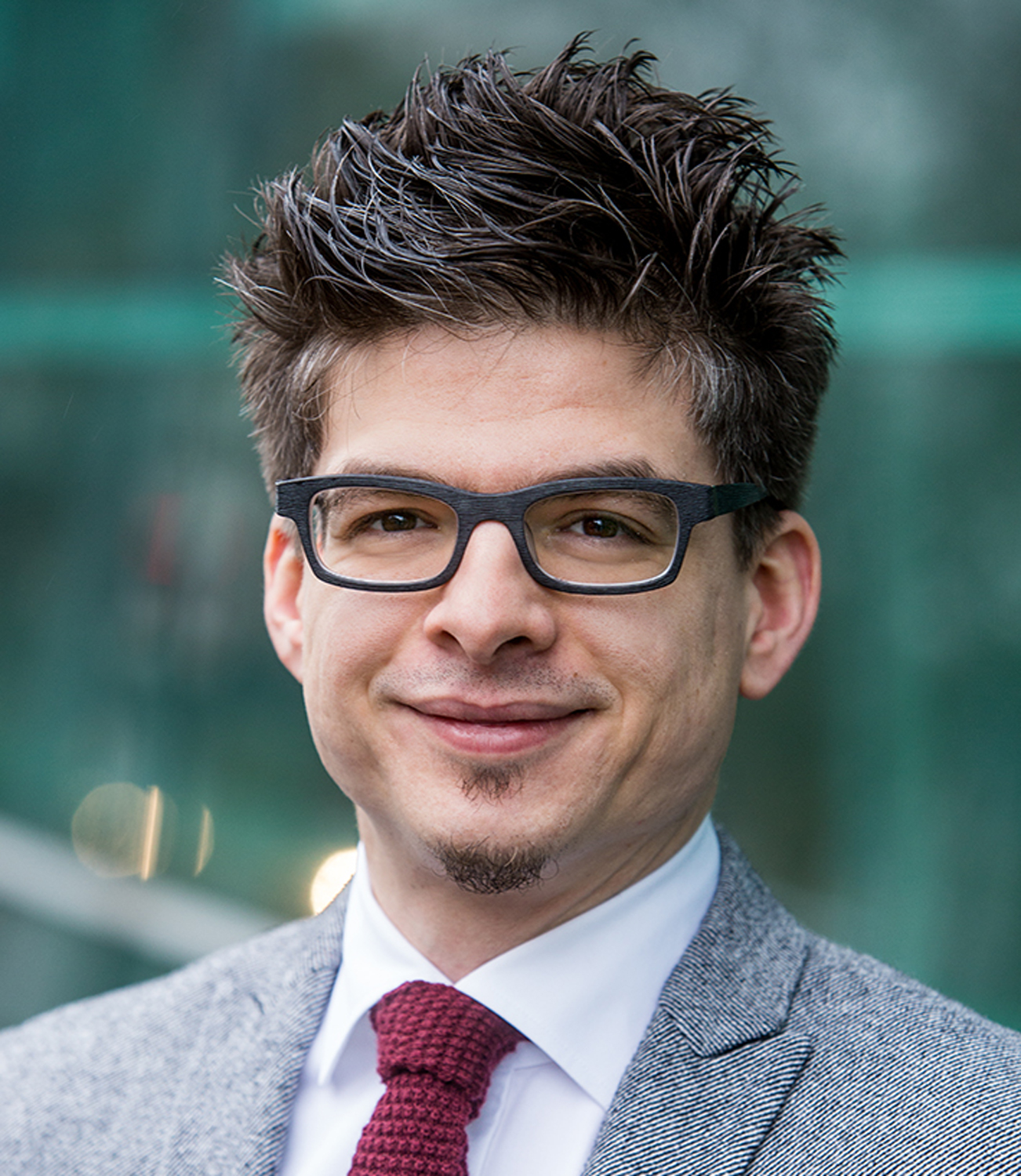 Photo of the mathematician Ingo Ullisch in a gray suit and red tie