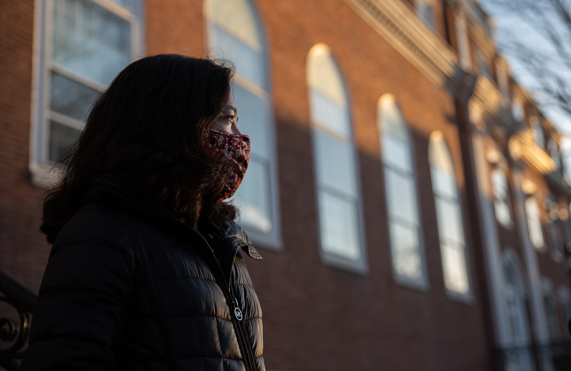 Williams wearing a mask and standing in front of a brick building