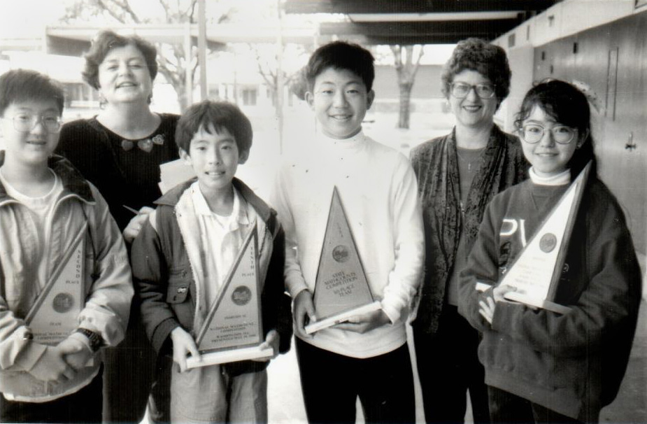 Williams standing with teachers and other students holding trophies from a math competition.