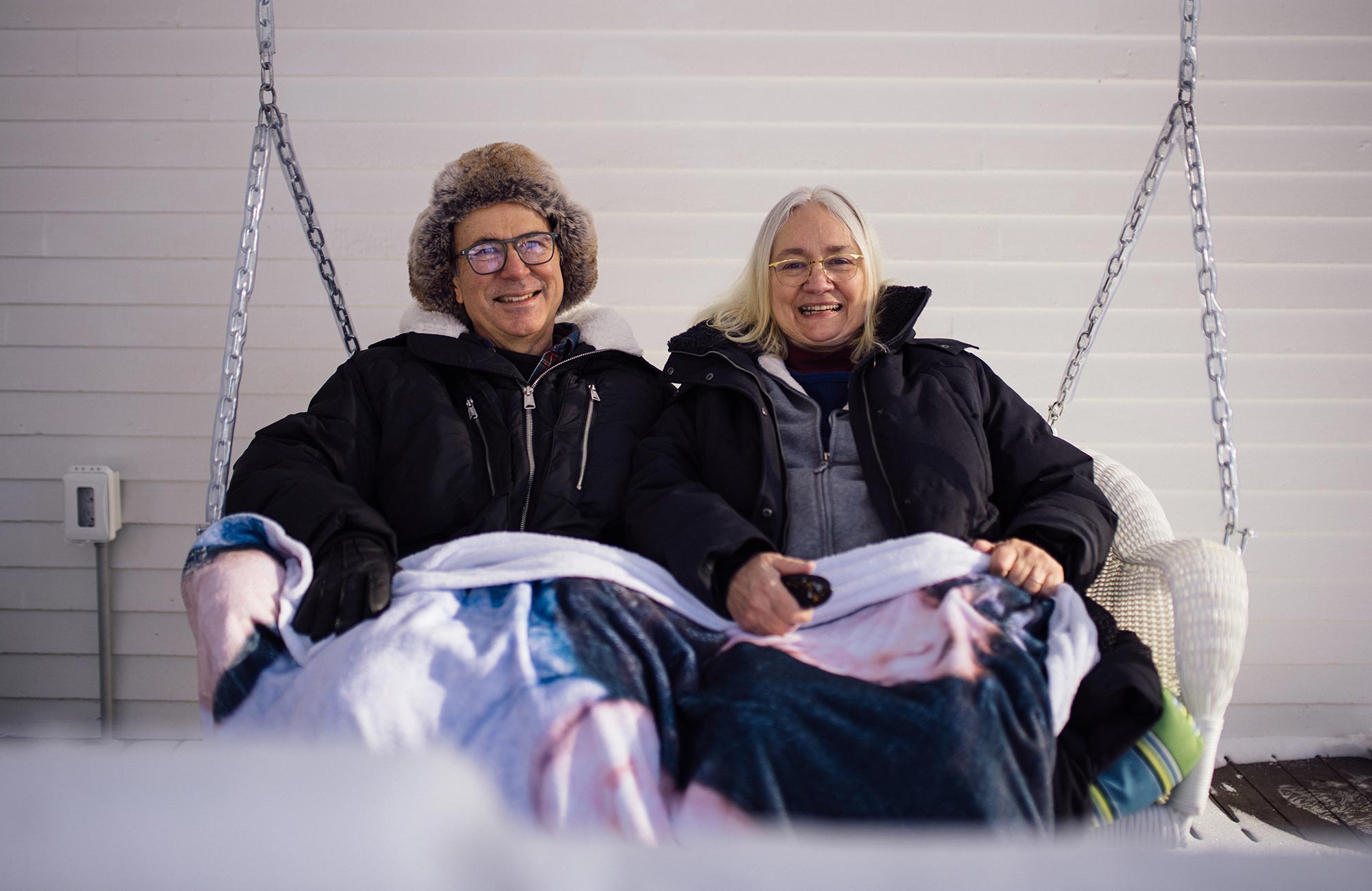 Frank Wilczek and his wife Betsy Devine sitting on a porch swing.