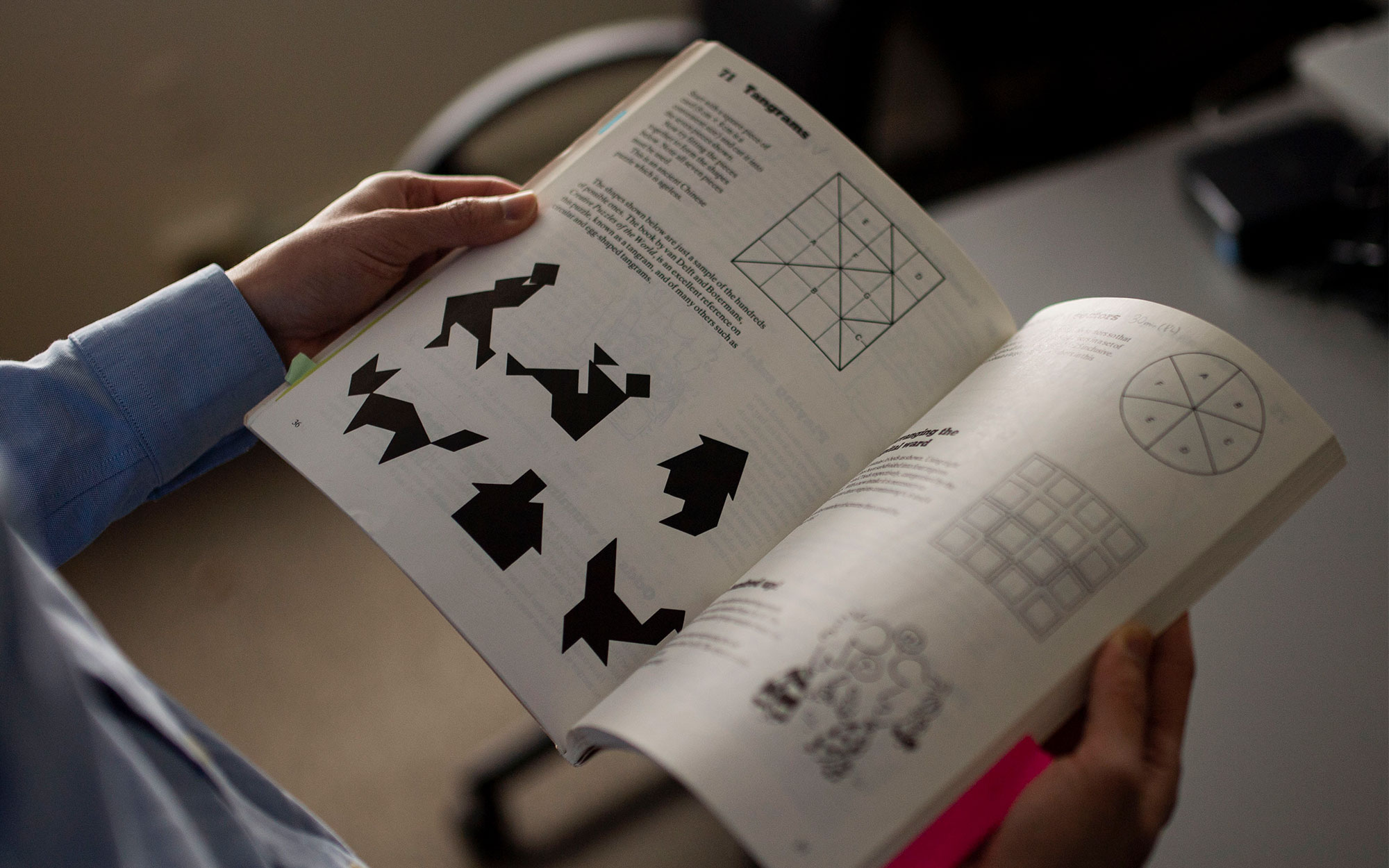 On the left, a close-up of Po-Shen Loh's hands holding open a book of math puzzles. On the right, the front cover of the book.