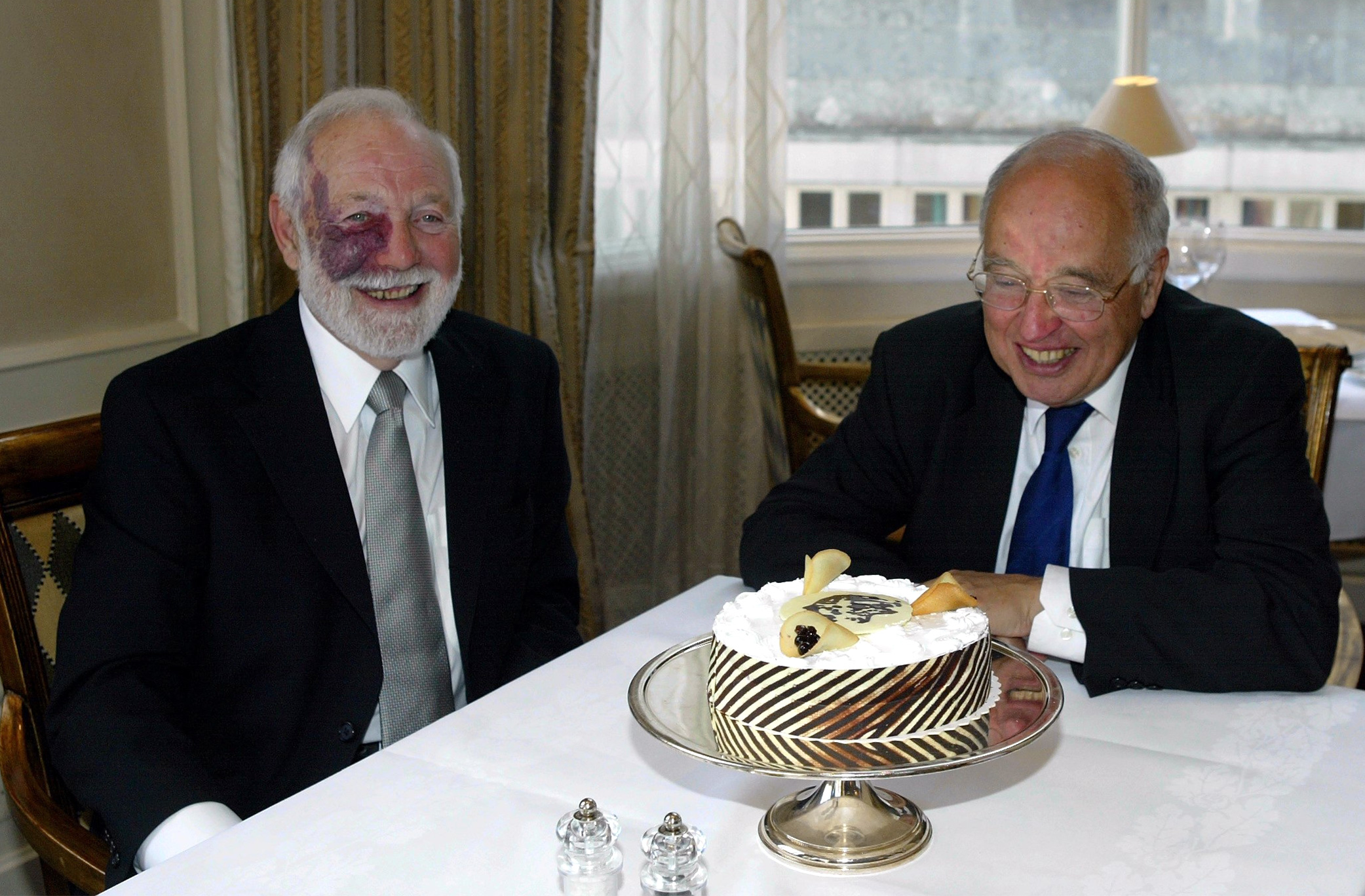 Photo of Isadore Singer and Michael Atiyah formally dressed and sitting at a dinner table