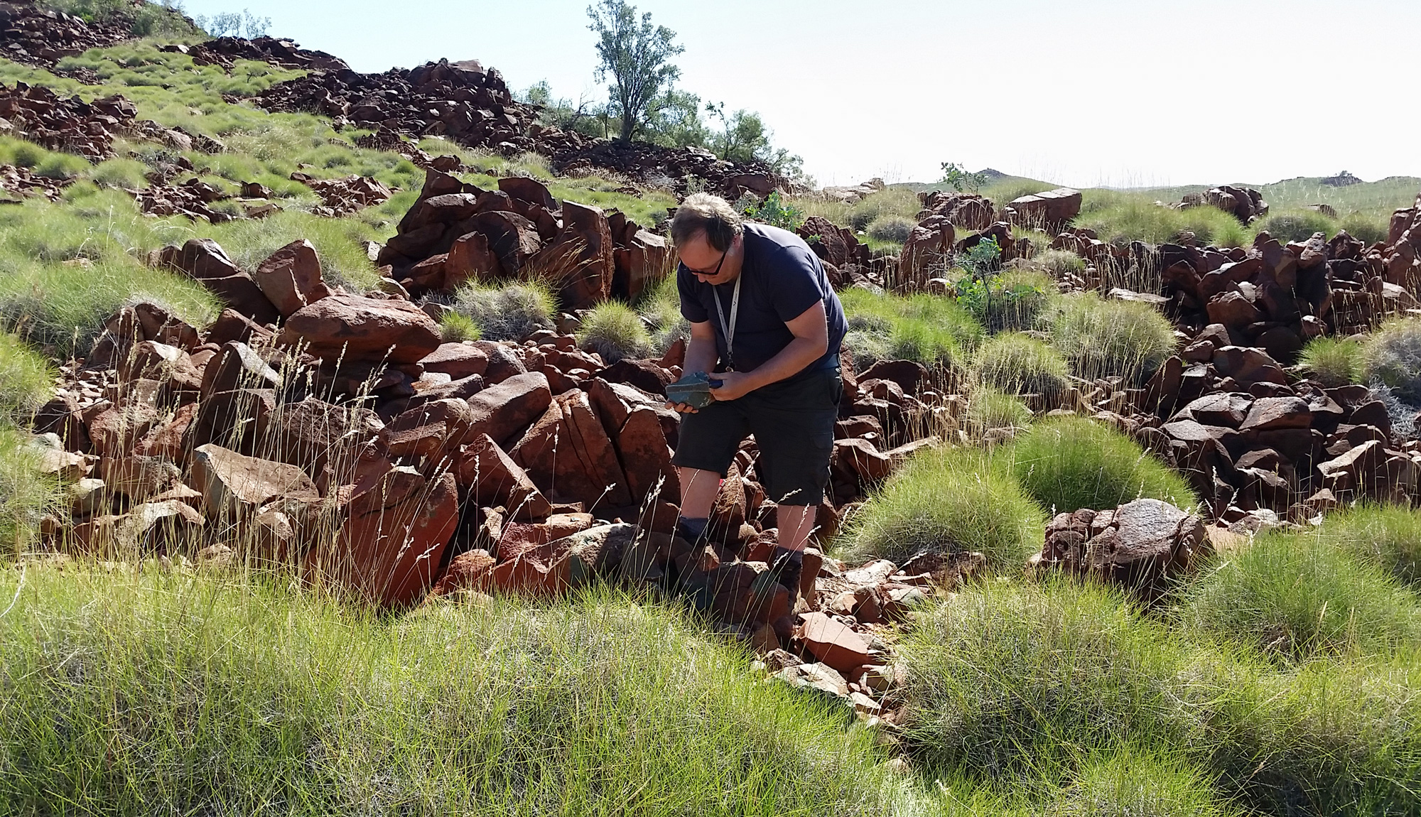 A diptych of photos of Jonas Tusch and Carsten Münker sledgehammering hilly outcrops.