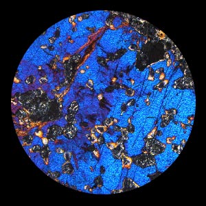 A mosaic of five microscope images of igneous rocks. The rocks are dappled with blue, pink, orange and multicolor inclusions.