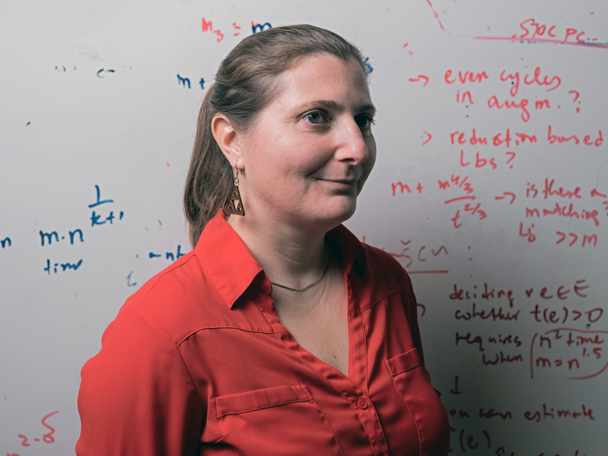 A color photo Virginia Williams in a red shirt in front of a whiteboard, and a color photo of Josh Alman in a gray shirt with a gray background