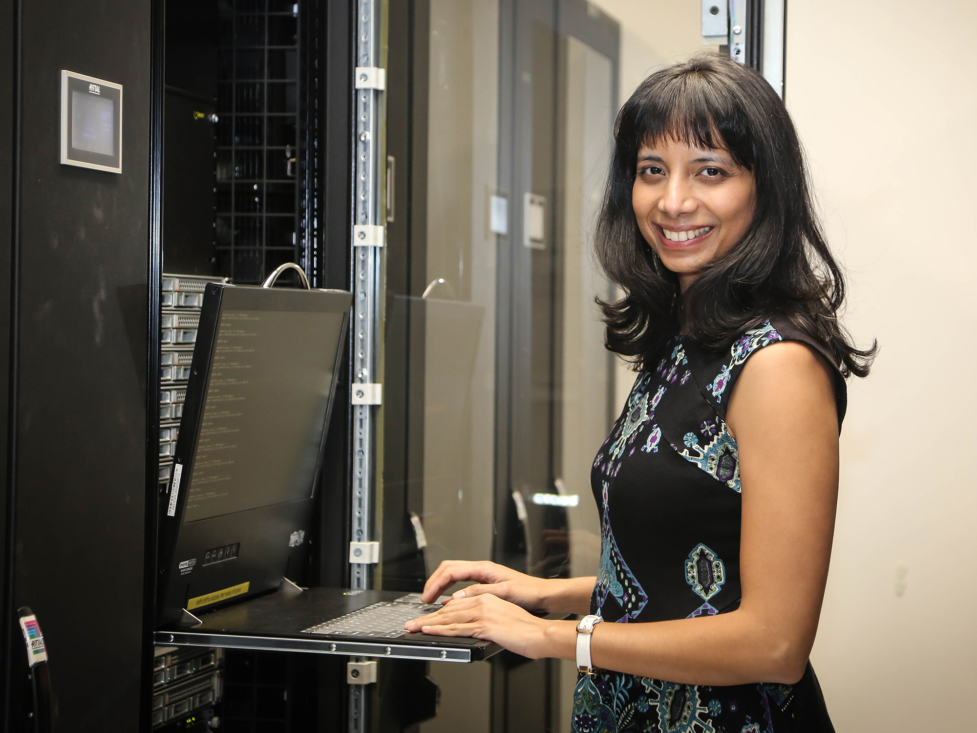 Anima Anandkumar standing outside a glass building